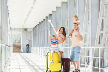 Happy family at the airport with suitcases traveling
