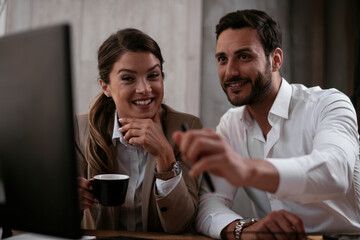 Businessman and businesswoman in office. Two friends drinking coffee while working on the project..
