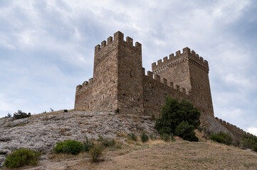 Fototapeta na wymiar old castle in the mountains against the blue sky, old tower of a defensive fortress