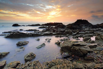 Fototapeta na wymiar Sea and rocks with beautiful sunset in the background