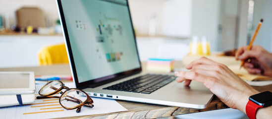 Man sitting at home and working remote using laptop at the kitchen. Private house workplace. Wide...