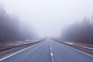Fototapeta premium road in fog concept, mist in october halloween landscape, highway