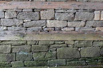 Wooden bands and dry-stacked rubble stone masonry. Abstract background texture.