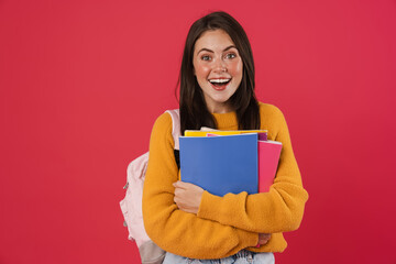 Image of excited beautiful student girl posing with exercise books