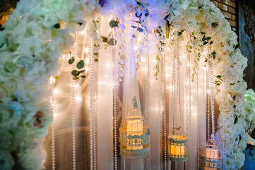 Wedding ceremony with a vintage candles. Arch for wedding area a is decorated with white flowers and greenery.