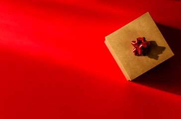Cardboard box with red bow on red background