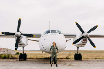 Fototapeta na wymiar Confident woman pilot wearing uniform, standing in front of an airplane.