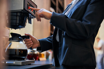 Close up of young woman that standing near coffee-machine