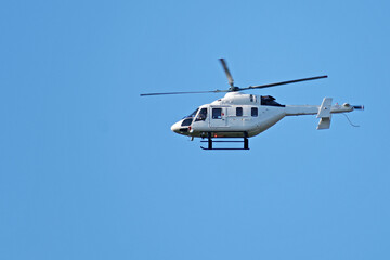 Bottom view of a small helicopter against the blue sky
