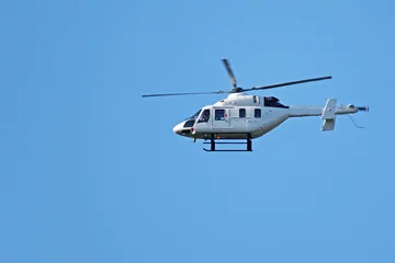 Sierkussen Onderaanzicht van een kleine helikopter tegen de blauwe lucht © vladimir subbotin