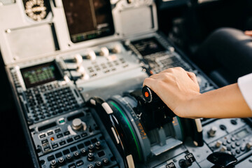 Fototapeta na wymiar Pilot hand on airplane engine control board in cockpit.