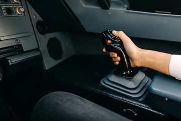 Pilot hand on airplane control joystick.