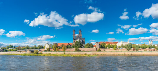 Panoramic view over downtown of Magdeburg, old town, Elbe river and Magnificent Cathedral at early Autumn, Germany, at sunny day and clear blue sky with funny clouds. - obrazy, fototapety, plakaty