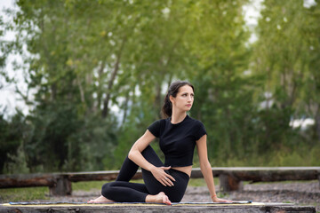 Fototapeta na wymiar a woman does yoga and stretching in a Park