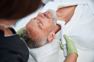 Fototapeta na wymiar Senior citizen enjoying facial skin treatment at spa
