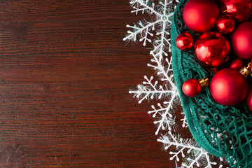  Red Christmas toys in a string bag on a brown wood background