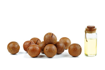 Macadamia nuts and oil on white background