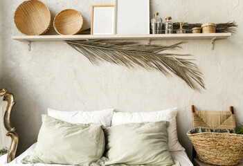 Minimal home interior bedroom design in boho style. Pillows, blanket and decorations.