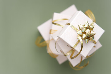 Close up view of gift with golden ribbon. Green background. Christmas concept
