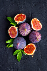 Tasty fresh figs cut in half with leaves, top view