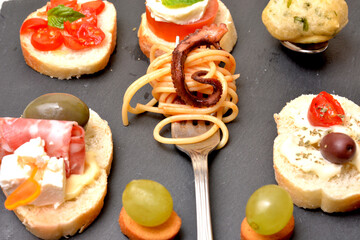 varietà di tapas con ingredienti italiani mozzarella gorgonzola pomodori olive polpo spaghetti salame frittelle di alghe di mare cibo mediterraneo