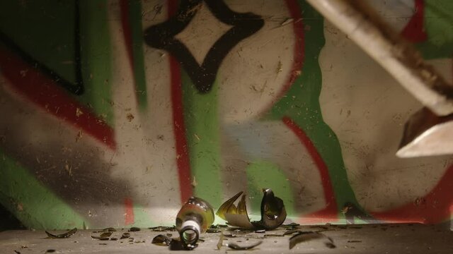 Bottles getting crushed by large hammer slow motion footage