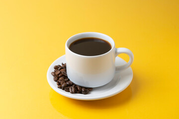 cup of coffee with grains and yellow background