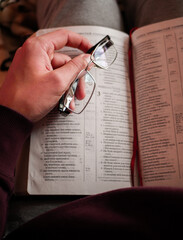 glasses and a book in human hands