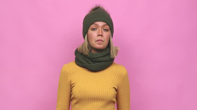 Young cute woman winter clothes shrugs shoulders and open eyes confused
