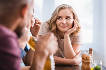 selective focus of excited young woman near multicultural friends during party