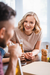 selective focus of young woman looking at multicultural friends during party