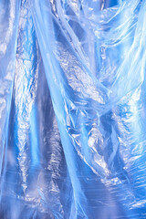 Abstract blue background of colorful textured holographic polyethylene plastic production.