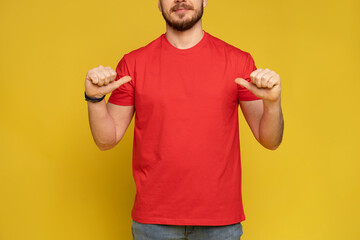 Happy man from delivery service in red t-shirt and cap isolated over yellow.