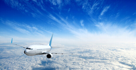 White airplane flying above clouds in the sky
