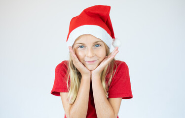 Close up portrait of a little girl in a red dress and red Christmas Santa hat
