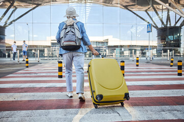 Woman with baggage walking across the street