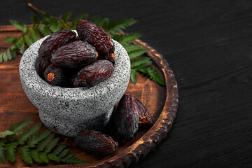 Bowl of dried dates on dark wooden background