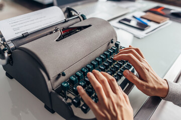 Women's hands typing on an old typewriter