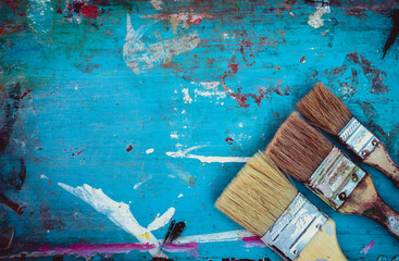 Vintage paint brushes. Old brushes on a wooden background covered with paint