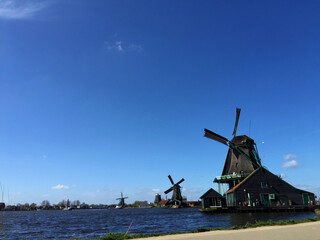 dutch historic windmills near sea coast at blue sky, in Zaanse Schans, North Holland, Netherlands