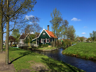 Fototapeta na wymiar landscape with village and river against blue sky in Zaanse Schans, North Holland, Netherlands