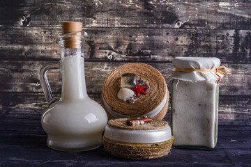 Obraz na płótnie Canvas The lay composition with body care products and space for text on dark wood background. a jar of natural cream, a bottle of coconut oil
