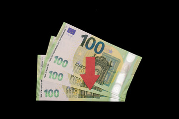 tree hundred euro bills on a black background with a red down arrow. Falling of EURUSD