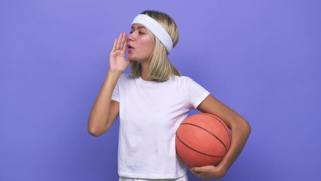 Young basketball player woman shouting and holding palm near opened mouth