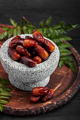 Bowl of dried dates on dark wooden background