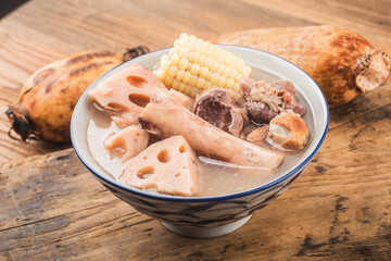 A bowl of pork bone lotus root soup on a wooden table