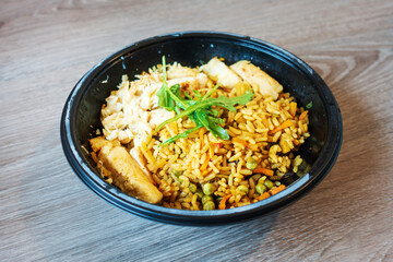 Wok rice cooked with soy sauce, vegetables and chicken pieces.