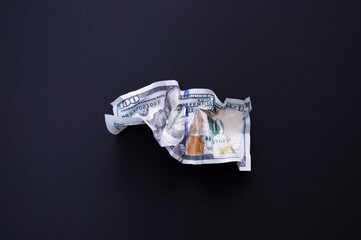 Crumpled one hundred dollar bill on a black background. The concept of the fall of the dollar as a result of the coronovirus pandemic. Copyspace