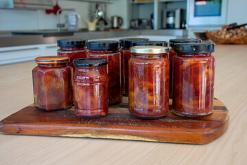
delicious homemade plum jam on the kitchen table in different jars