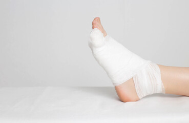 Man's bandaged foot with little finger on a white background. The concept of a fracture of the...
